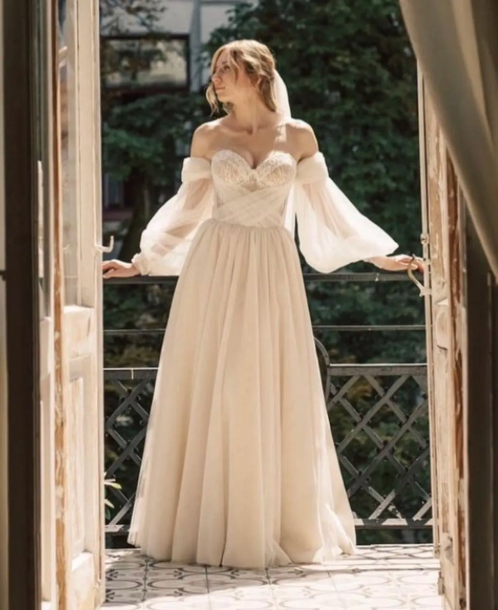Indulge in luxury with our Robe Johanna, a boho wedding dress with A-line silhouette and sweetheart neckline. The lantern sleeves and off-shoulder design add a touch of elegance, while the criss-cross back and intricate beadwork make for a truly unique piece. Be the center of attention in this floor-length gown, perfect for any bride looking for something new and stunning.
