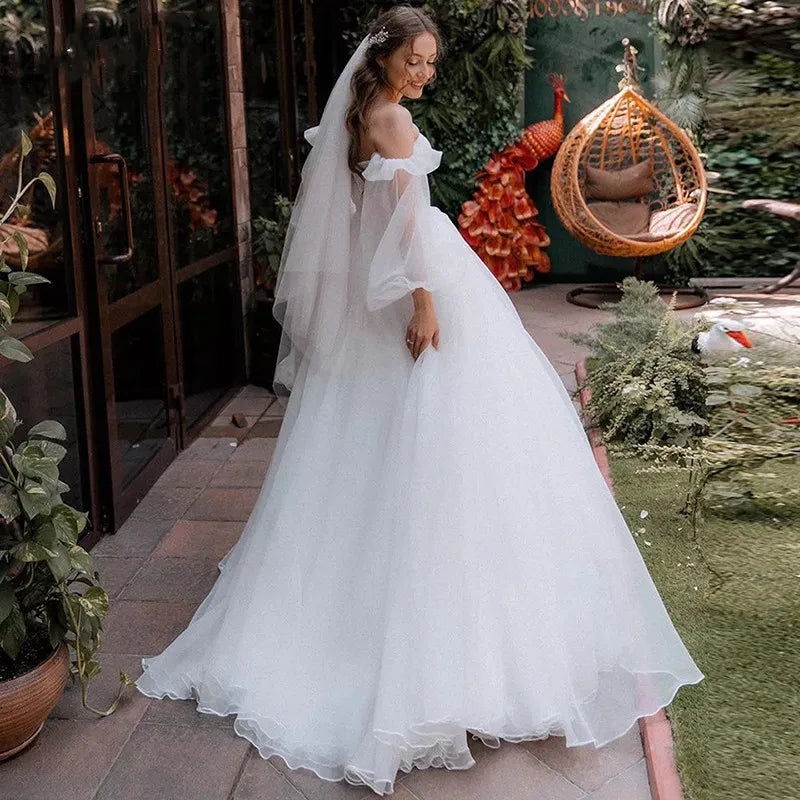 The Robe Oriane is the perfect princess wedding dress for any bride-to-be. Featuring a strapless design and puff long sleeves, this gown exudes elegance and grace. The off-shoulder court train adds a touch of luxury, while the organza material provides a simple and sophisticated look. Feel like royalty on your special day with this stunning bridal gown.
