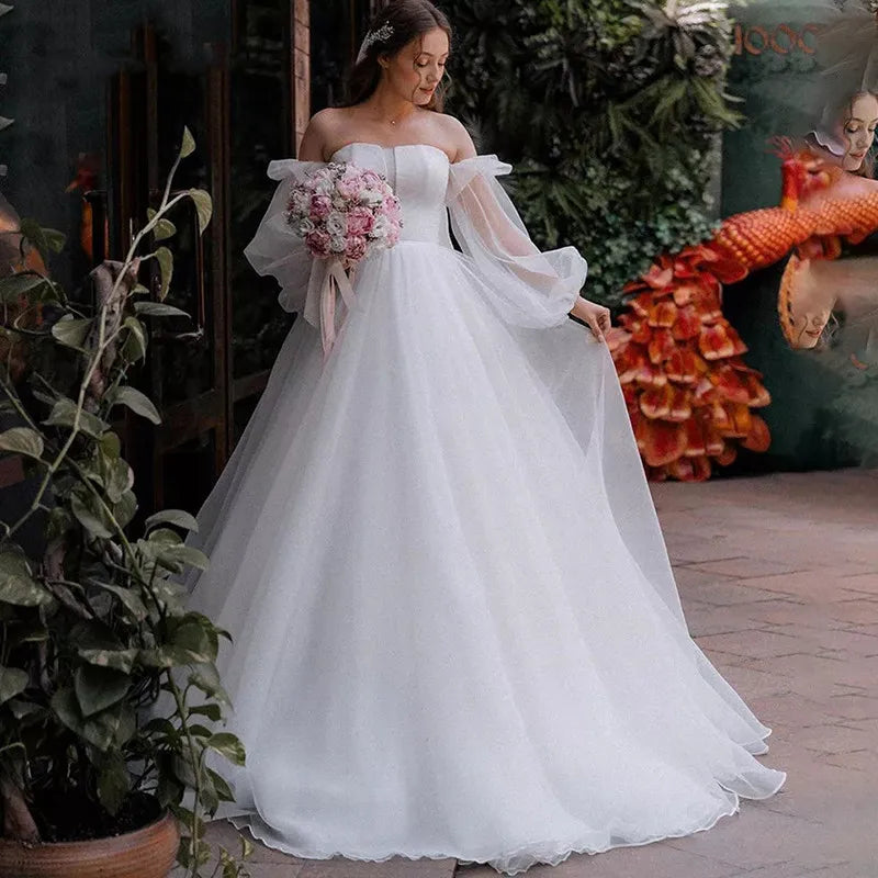 Robe Oriane is the perfect princess wedding dress for any bride-to-be. Featuring a strapless design and puff long sleeves, this gown exudes elegance and grace. The off-shoulder court train adds a touch of luxury, while the organza material provides a simple and sophisticated look. Feel like royalty on your special day with this stunning bridal gown.
