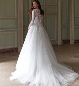 Unleash your fearless spirit with the Robe Lynette. This vintage lace wedding dress boasts a dramatic A-line silhouette, full sleeves, and delicate lace appliques adorned with sparkling sequins and beads. With a daring O-neckline and sweeping train, this dress is perfect for the adventurous bride ready to take on anything!