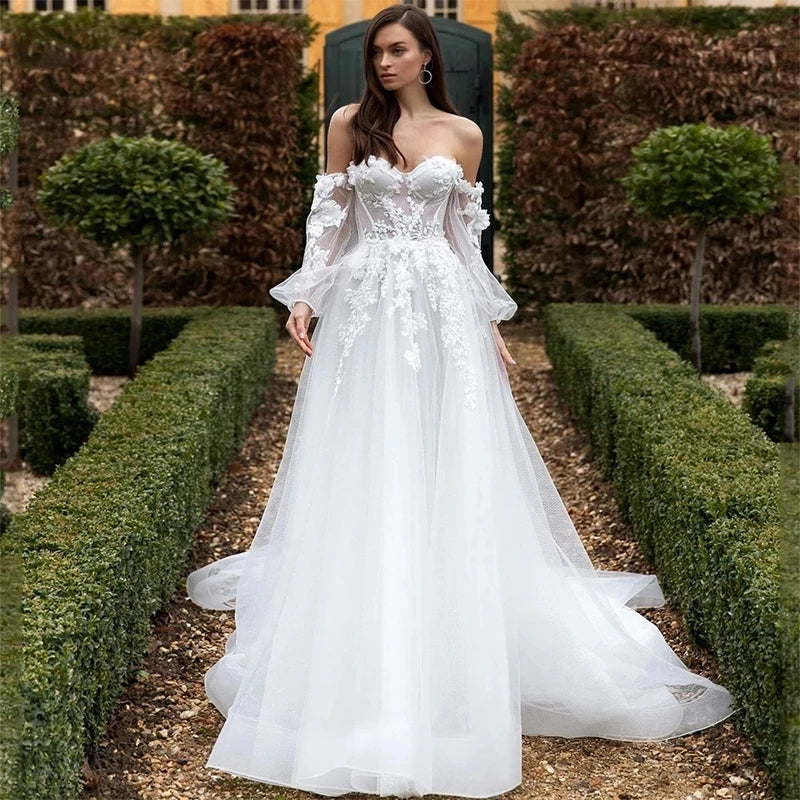 The Robe Capriana features a beautiful combination of cap sleeves and strapless design, creating a stunning wedding dress. Intricate appliques adorn the organza material, with a long court train and a backless silhouette adding elegance and charm. Perfect for a stylish and modern bride.