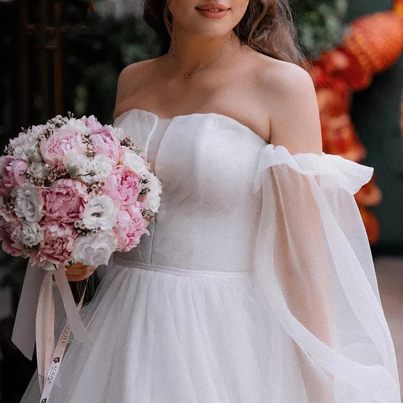 Robe Oriane is the perfect princess wedding dress for any bride-to-be. Featuring a strapless design and puff long sleeves, this gown exudes elegance and grace. The off-shoulder court train adds a touch of luxury, while the organza material provides a simple and sophisticated look. Feel like royalty on your special day with this stunning bridal gown.
