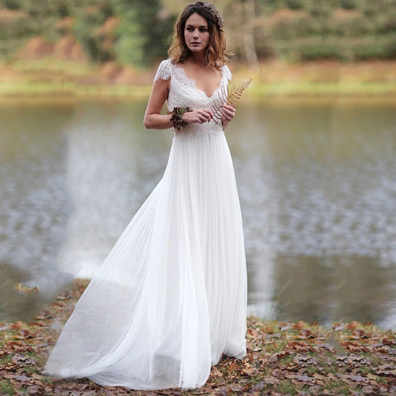 Make your special day even more perfect with Dress Arlene. This beautiful summer boho wedding dress features a V neckline and cap sleeves, perfect for a beach wedding. Crafted from chiffon, it exudes effortless elegance and will have you feeling comfortable and stunning all day long.