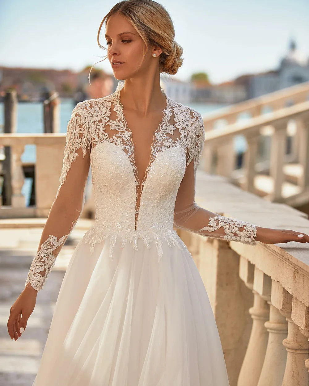 The Robe Angelique is the perfect choice for a vintage-inspired wedding. With delicate lace appliques and long sleeves adorned with buttons, this dress exudes timeless elegance. Feel like a princess on your special day with this stunning bridal dress.