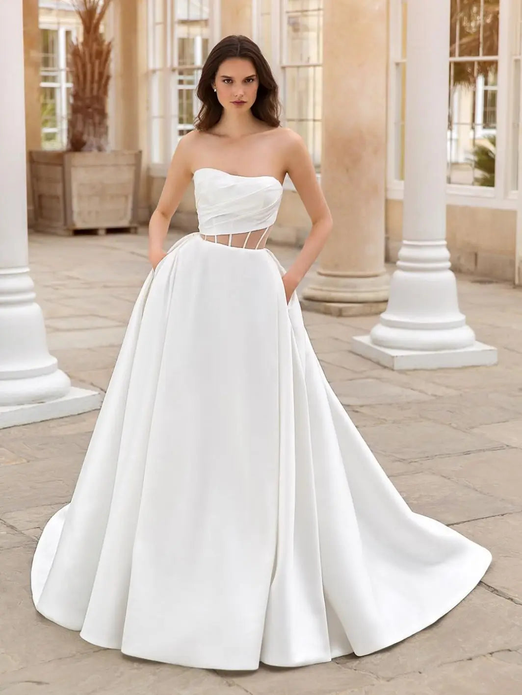 This 2-in-1 wedding dress offers versatility and style for a bride on her special day. It features a detachable ball gown with an off-shoulder design and a long, sheer tail for a dramatic entrance. The pleated bodice adds a touch of elegance and glamour, making it the perfect dress for any bride.