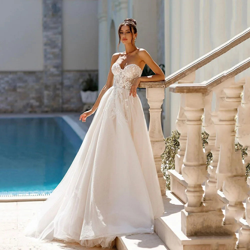 Indulge in the timeless elegance of the Robe Ariane. Adorned with intricate lace and sweet appliques, this A-Line bridal gown is fit for a princess on her special day. With a sweetheart neckline, it exudes grace and sophistication. Your fairy tale wedding awaits.