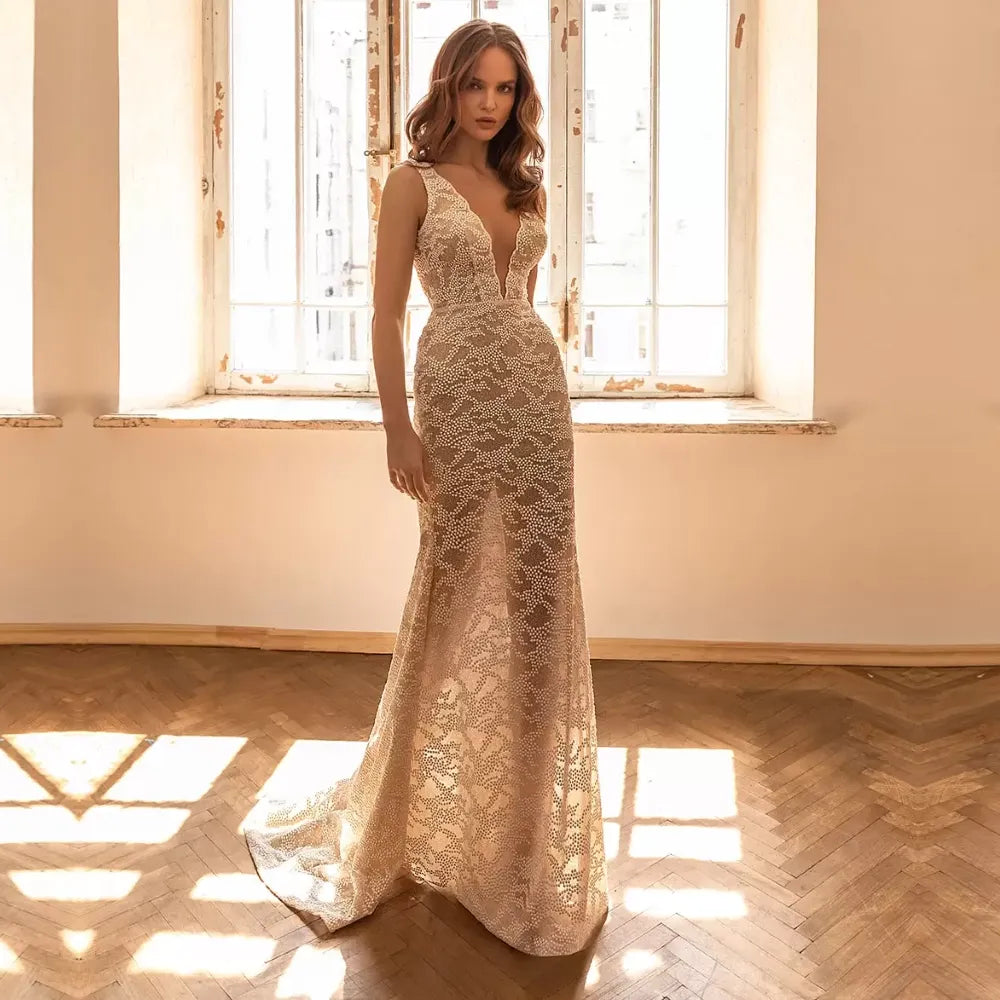 Experience elegance and grace with our Dress Anoushka. Designed for the modern bride, this dress features a flattering V-neckline, delicate spaghetti straps, and intricate lace details. Walk down the aisle confidently in this stunning sheath gown, perfect for any wedding.