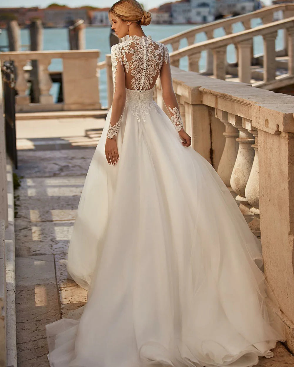 The Robe Angelique is the perfect choice for a vintage-inspired wedding. With delicate lace appliques and long sleeves adorned with buttons, this dress exudes timeless elegance. Feel like a princess on your special day with this stunning bridal dress.