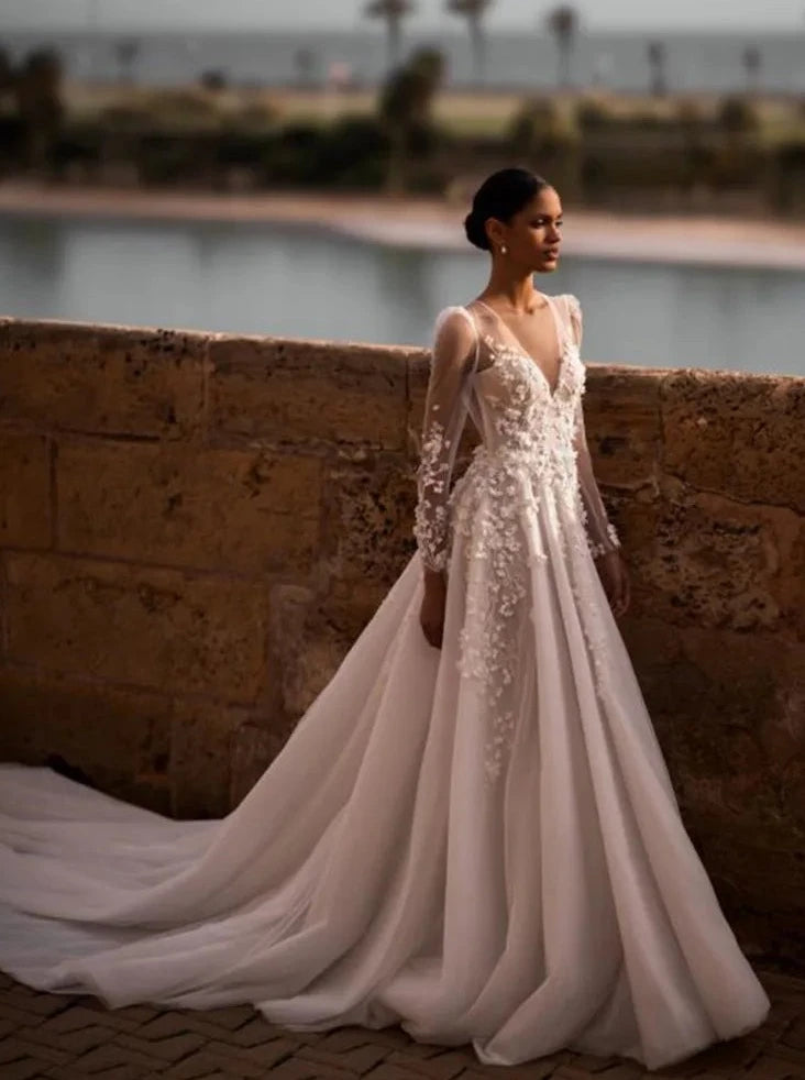 Indulge in timeless elegance with our Robe Nina. Featuring a delicately crafted lace design and long sleeves, this wedding gown is the perfect choice for your special day. Experience the luxury and sophistication of our exclusive collection.