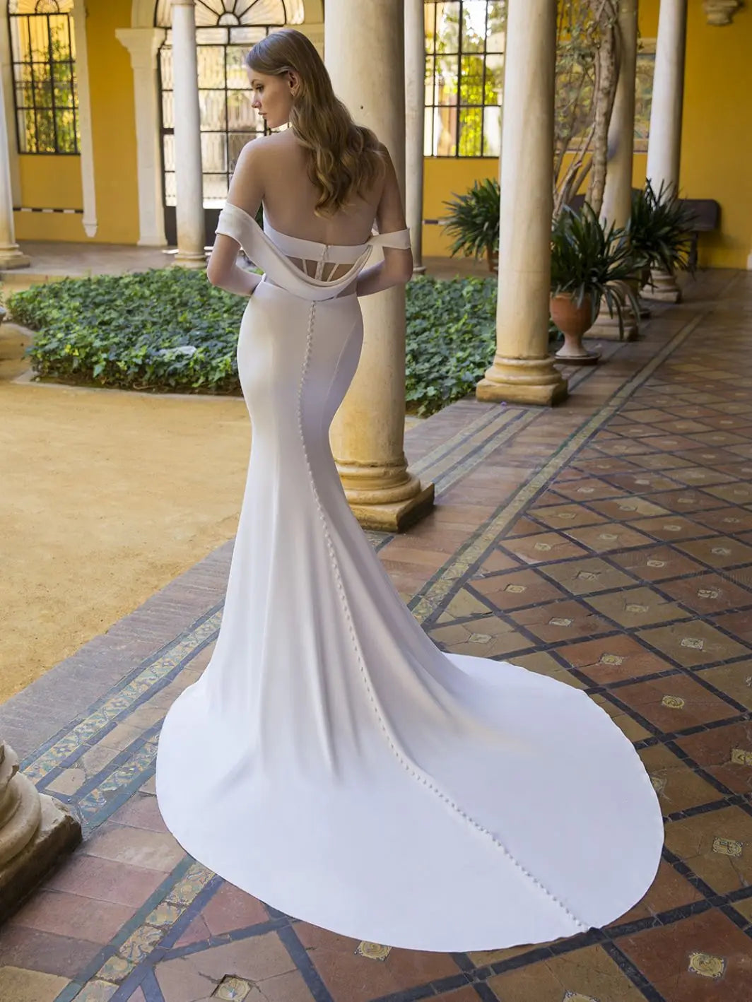 Get ready to be the belle of the ball with Dress Penelope! This mermaid-style wedding dress features an off-shoulder sweetheart neckline, pleated bodice, and an illusion corset back for a stunning silhouette. Made with luxurious crepe, you'll feel like a true bridal beauty. Say yes to Dress Penelope!