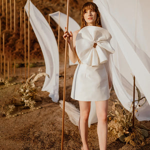 Perfect for your special day, this gorgeous Robe Brittany features beautiful handmade flowers, petite pearls and spaghetti straps that'll make sure you feel like royalty. With a classic strapless mini satin look and a simple backless style, you'll look stunning no matter the occasion!