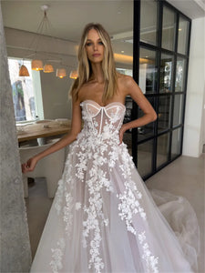 Enhance your special day with our Robe Eva. This stunning wedding dress features a flattering sweetheart neckline and elegant sleeveless design, giving you a timeless A-line silhouette. Adorned with delicate flowers, this bridal gown will make you feel like a beautiful bride on your big day.