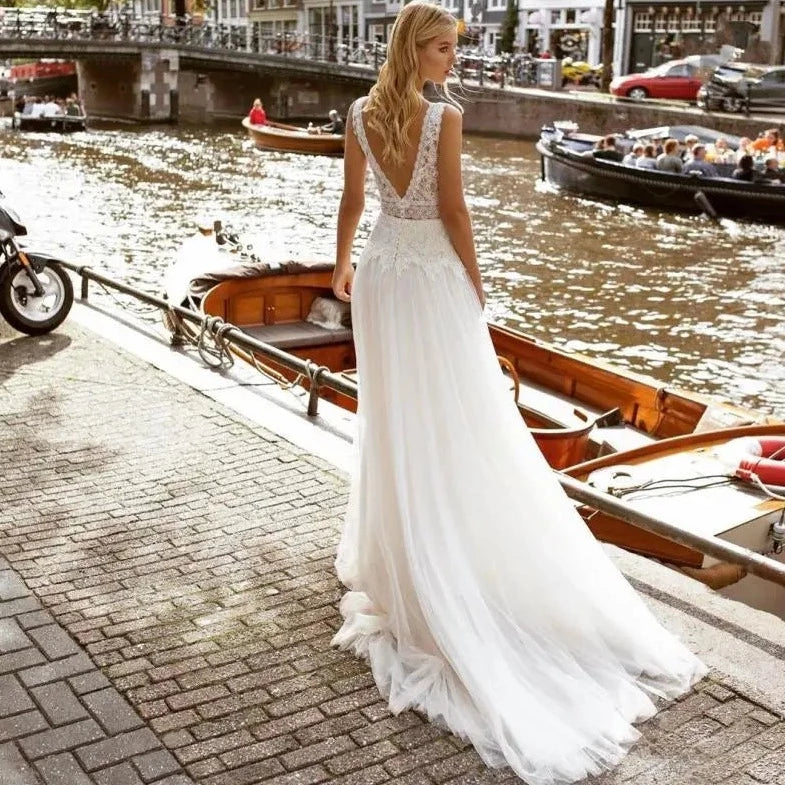 Indulge in the luxuriously delicate and intricate design of the Robe Solene. Featuring a beach lace backless style with applique tulle and a v-neck, this sleeveless Bohemian bridal gown exudes elegance and grace. Its sweeping train and vestido de noiva silhouette make it the perfect choice for a beach wedding.
