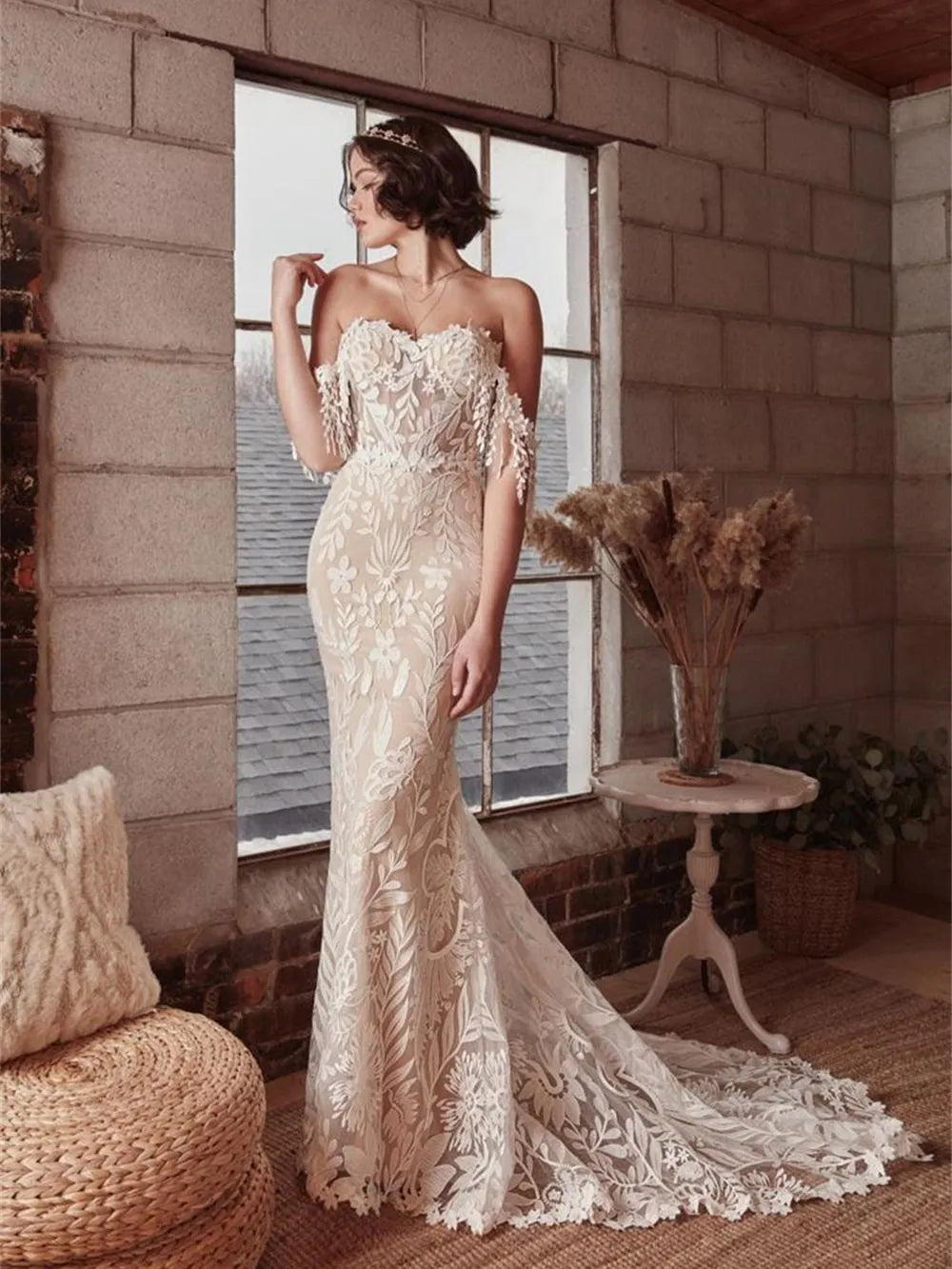 This Robe Cosette wedding dress is the perfect mix of sweet and sexy. The sheath silhouette and delicate lace fabric are complemented by an off-the-shoulder neckline and sweep train. Highly flattering and comfortable, this bridal gown is perfect for a church or civil wedding.