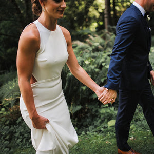 Walk down the aisle in style and comfort with our Dress Ghislaine. This stunning wedding dress features a round neck halter and a beautiful open back design, all made from high-quality satin crepe fabric. Its stretchy sheath silhouette and custom fit make it perfect for plus-size brides looking for a minimalist and elegant look on their special day.