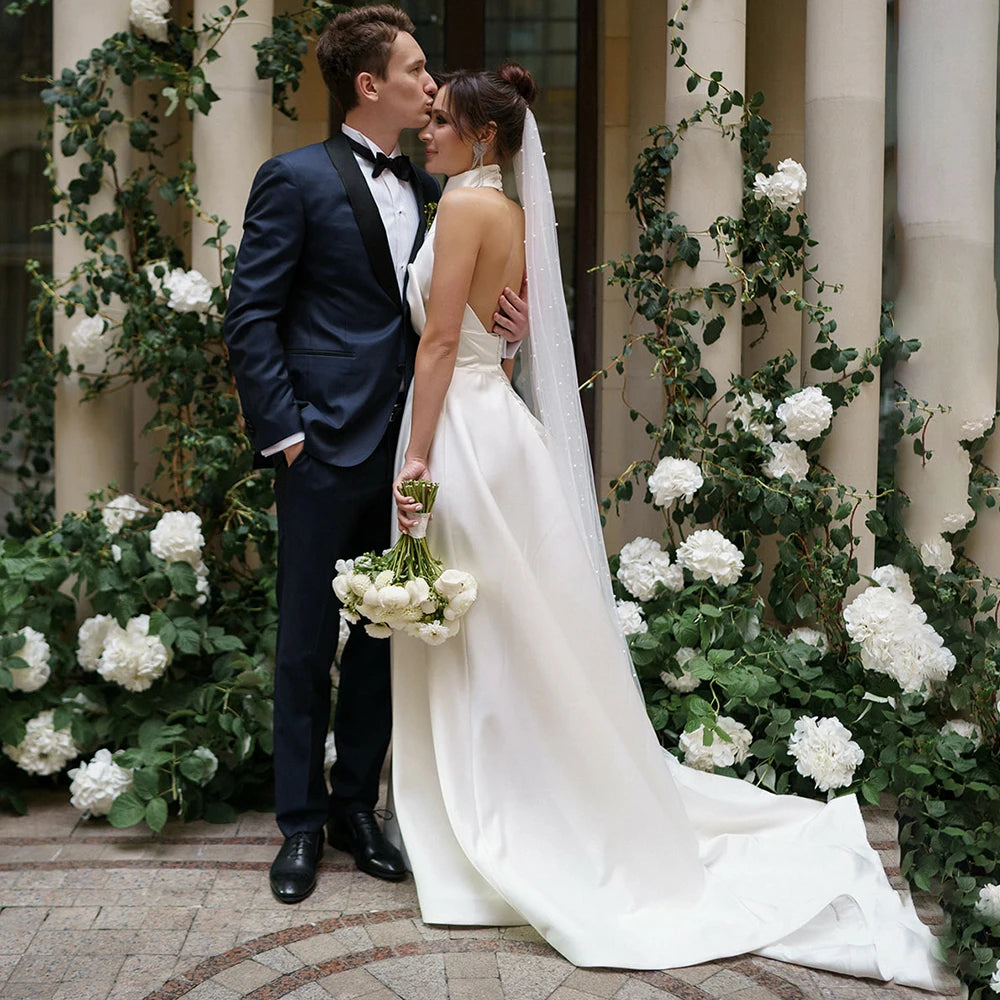Feel like royalty in this Robe Oceane wedding dress. Handcrafted with luxurious satin, this halter high neck dress features a minimalist design for an effortlessly sophisticated look. The backless design with a large bow trailing the A-line silhouette is a timeless classic that will make you look and feel like a beautiful bride. Custom made and available in big sizes, make your special day even more special with this exquisite minimalistic yet sexy gown.