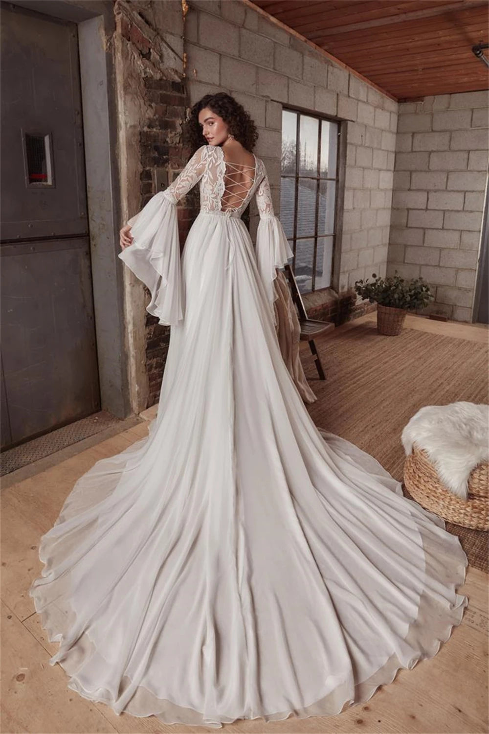 Indulge in luxury with the exquisite Dress Chamilla. This stunning wedding dress features an empire silhouette, elevated by a boat neckline and intricate lace detailing. The flowing chiffon fabric adds a touch of romance, making it the perfect choice for bridal gowns. Walk down the aisle in style and grace.