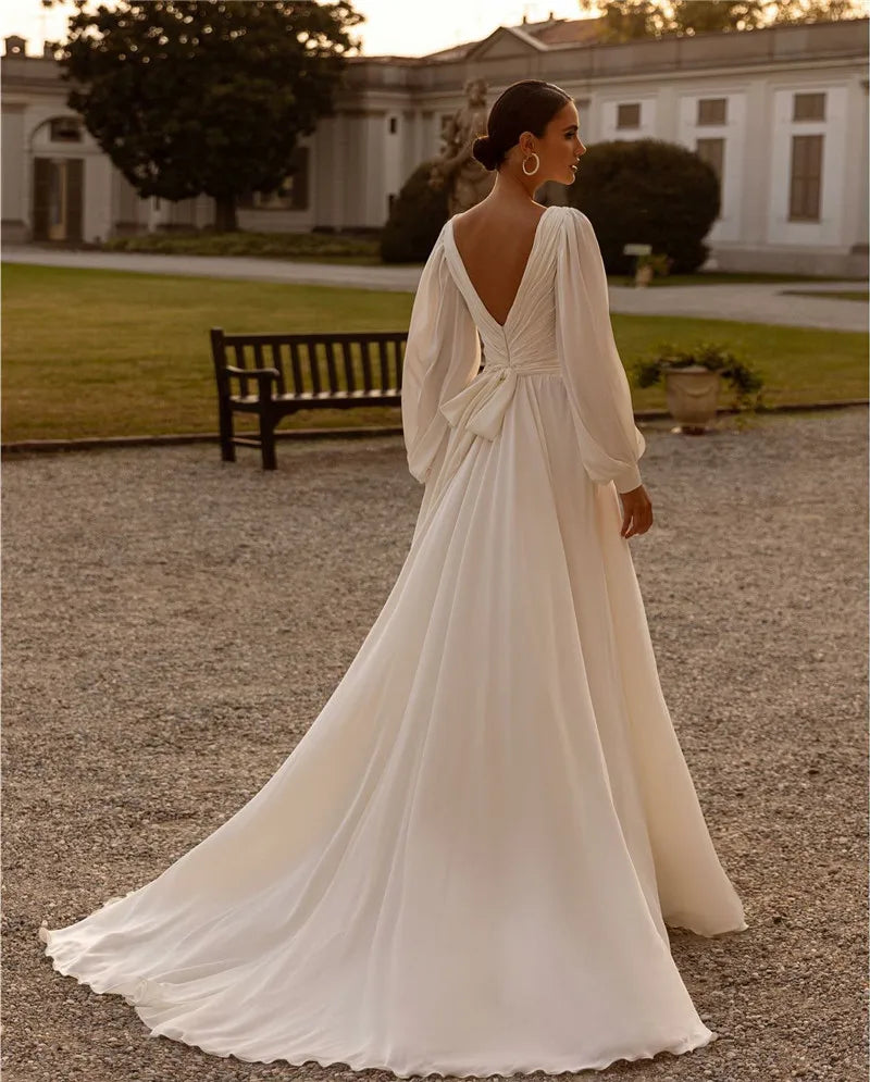 Embrace your inner bohemian goddess with Dress Michelle. The flowy chiffon and long sleeves create a dreamy A-line silhouette, perfect for a custom-made wedding dress. Add a touch of whimsy with the sweep train, making you feel like a true boho bride. Let your free-spirited style shine on your special day.