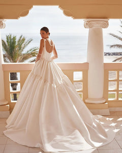 Experience the timeless elegance of the Britania Gown. Featuring a princess-cut silhouette and a square neckline, this Mikado wedding dress exudes sophistication and romance. Crafted with exquisite attention to detail, it is the perfect choice for brides seeking a classic and feminine look on their special day.