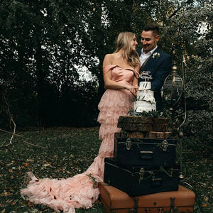 Elevate your wedding day in the exquisite off shoulder Robe Melissa. Crafted with delicate tiered lace in a dreamy mauve pink hue, this A-line custom-made gown is perfect for the plus-size bride. With a breathtaking long train and tutu details, this dress is a must-have for your elopement photoshoot.