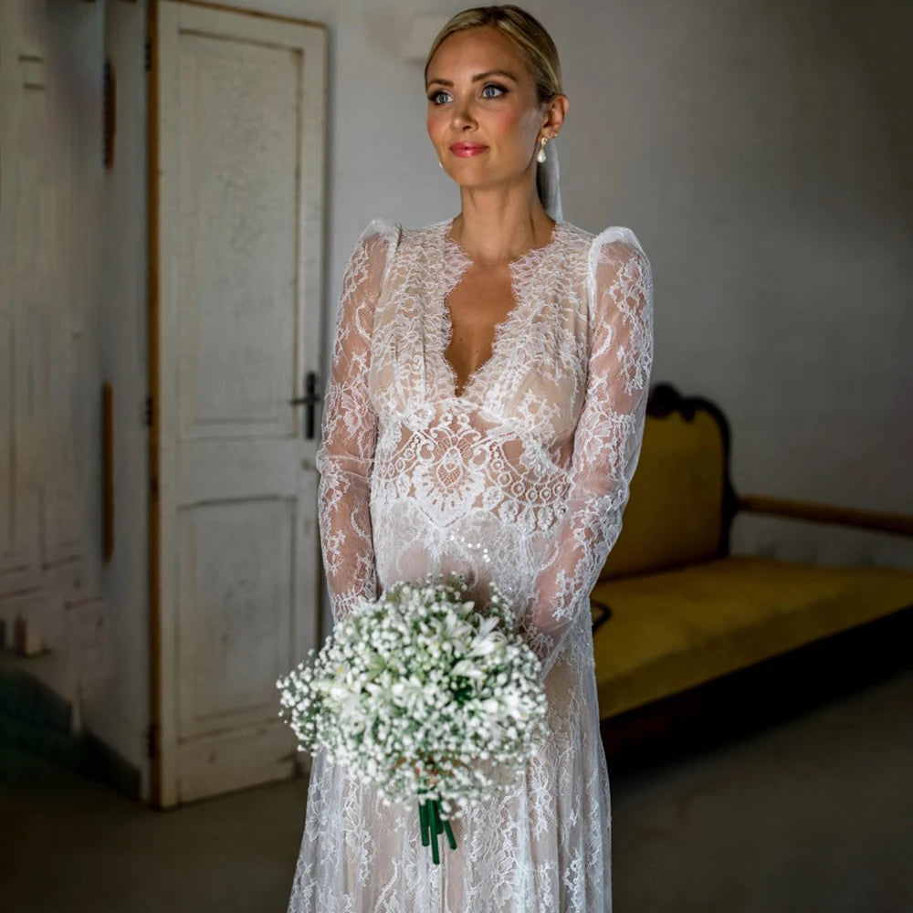 Capture a sophisticated look for your special day with the Robe Esme. Crafted in sheer lace, this plus size A line wedding gown features deep v neckline, long sleeves and boho maxi hipple design for a rustic yet luxe look. Perfect for photography, the dress is custom made to ensure a perfect fit. Create a timeless bridal look with Robe Esme.