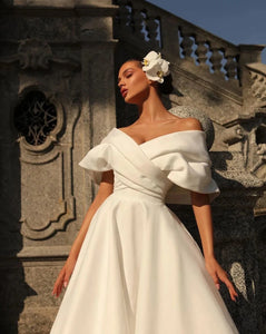 Feel like a true princess on your special day with the Robe Petrusia! The elegant A-Line silhouette, delicate cap sleeves, and intricate pleating create a timeless look that will make you feel confident and beautiful. Perfect for any bride looking for a classic and sophisticated wedding dress.