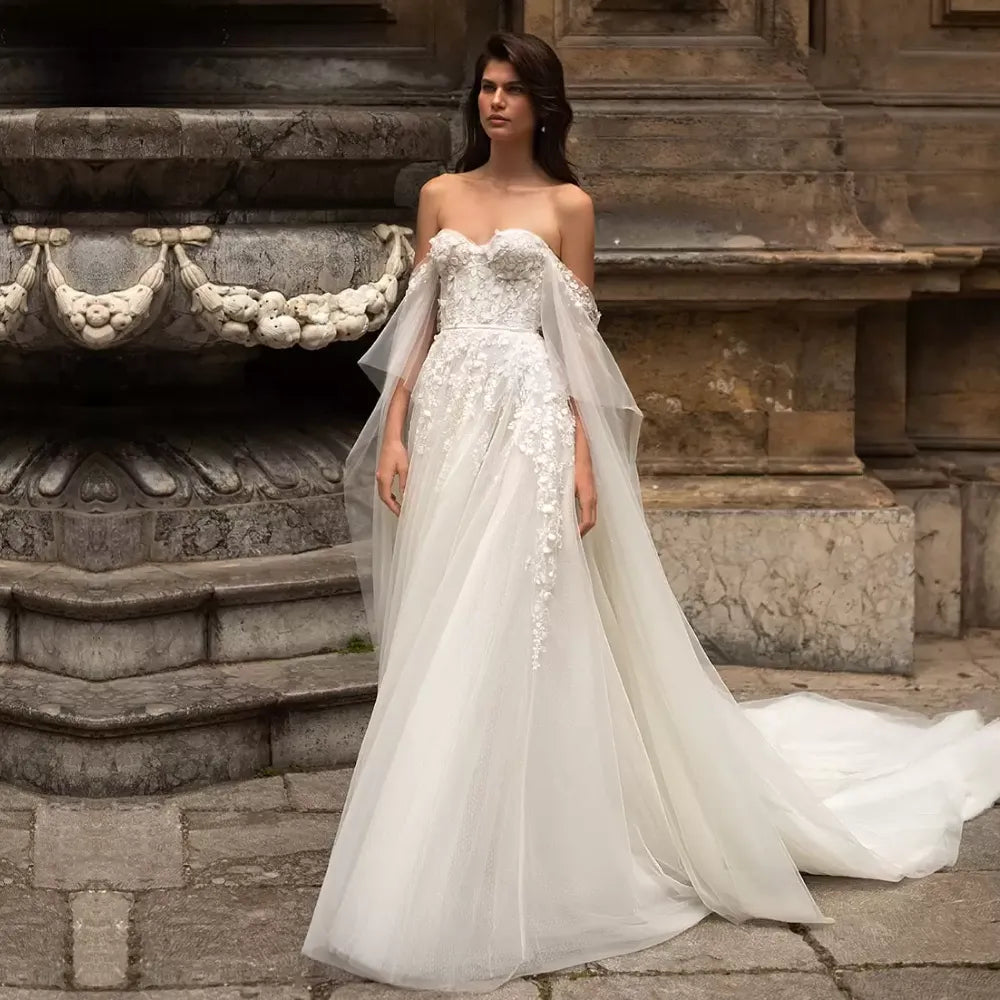 Look gorgeous for your special day in this Sydney Robe wedding dress. Off the shoulder sweetheart neckline with elegant applique detailing along the A-line tulle skirt creates a timeless and romantic look. Take the chance and live the dream in this stunning gown!