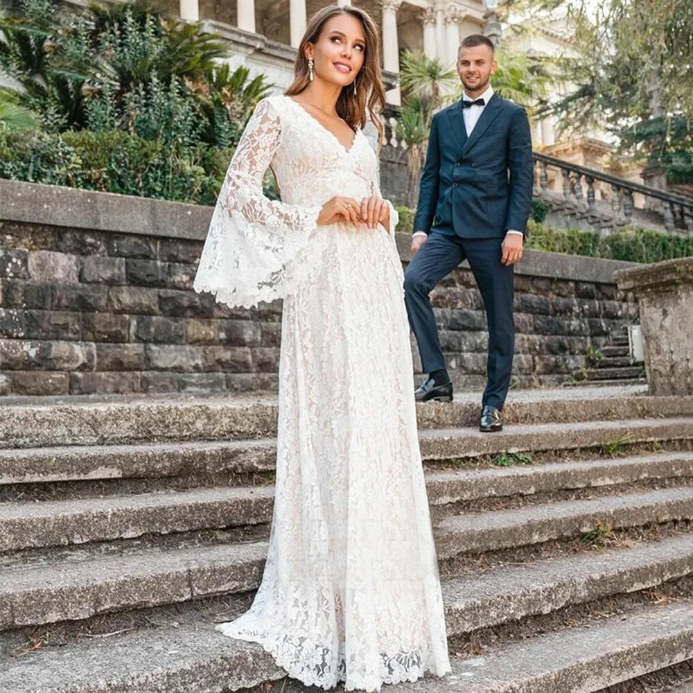 Indulge in luxury with our Dress Arabelle. Showcasing delicate scalloped lace and a plunging v-neck, this wedding dress is customizable with long bell sleeves and tassled ties at the back for a bohemian touch. Cutouts add a modern twist to this timeless piece. Perfect for the sophisticated and fashionable bride.