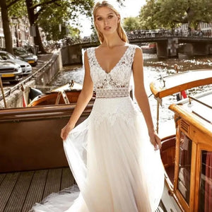 Indulge in the luxuriously delicate and intricate design of the Robe Solene. Featuring a beach lace backless style with applique tulle and a v-neck, this sleeveless Bohemian bridal gown exudes elegance and grace. Its sweeping train and vestido de noiva silhouette make it the perfect choice for a beach wedding.