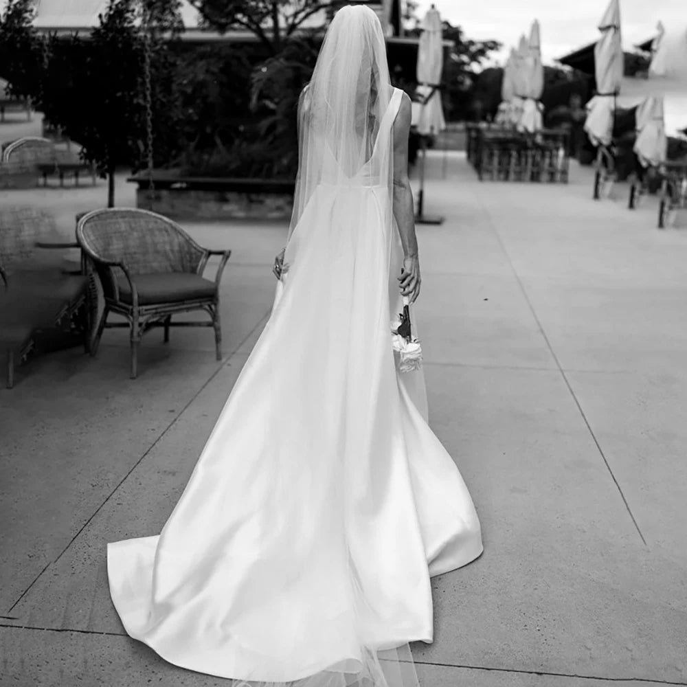Indulge in the luxurious simplicity of the Robe Aude. Handcrafted from the finest satin, this custom-made wedding dress features a high split and open back, adding a touch of sensuality to its minimalist design. Ruched details complete the look, creating a luxe and elegant dress for your special day.