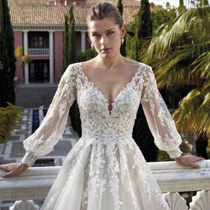 Elevate your special day with the Robe Khloe. This luxury wedding dress features long sleeves for a sophisticated touch, while the V-neck and backless design add a hint of sexiness. Indulge in the premium quality and craftsmanship of this bridal gown, making you feel like a true goddess on your wedding day.