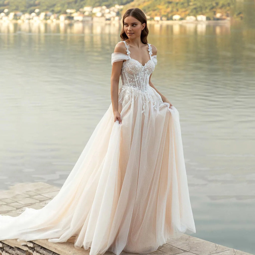 Captivate the room in this exquisite Robe Gigi. Crafted with luxurious lace appliques, a sweetheart neckline, and a figure-defining corset bodice, this romantic princess wedding gown looks as if it were poured from a Dutch Masters painting. Let the delicate tulle skirt and spaghetti straps drape gracefully, for a look that is both elegant and timeless.