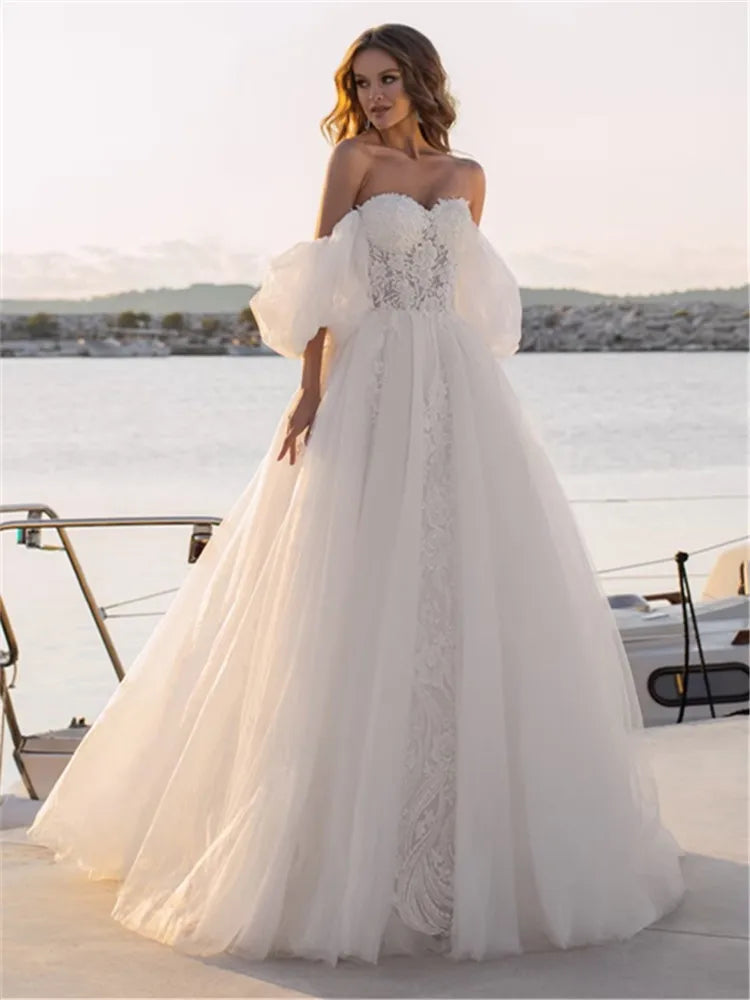Elevate your special day with our Robe Rene, a luxurious lace ball gown that exudes elegance and sophistication. The off-shoulder design adds a touch of romance, making you feel like a modern-day princess. Perfect for a wedding or any lavish event. Experience the ultimate in style and grace with our Robe Rene.