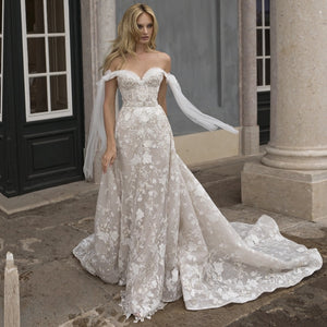 Make your wedding day extra special in our one-of-a-kind Robe Beau! This off-the-shoulder lace beauty will have you feeling like a princess, with its appliqué details, fit for a queen! Lace up your wedding day look with the Robe Beau and make it a moment you'll never forget!