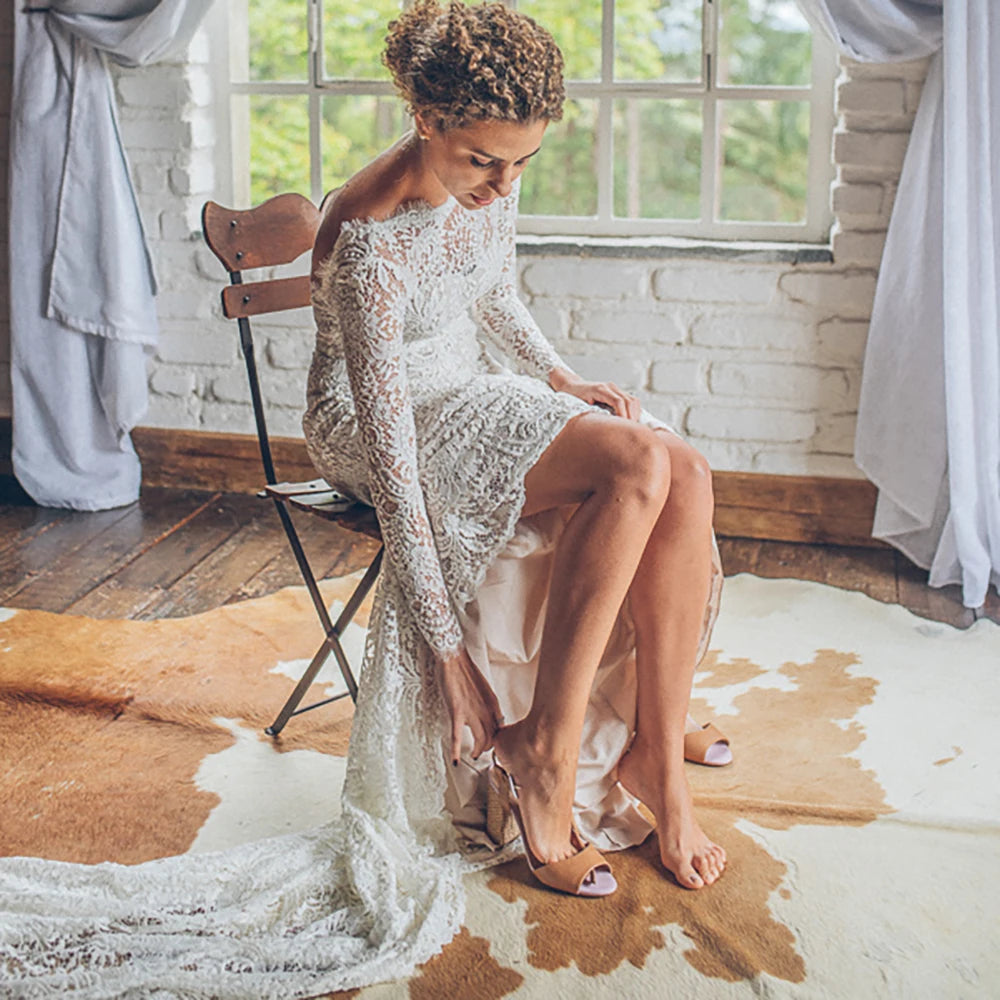 Look breathtaking in the Eleanore, a romantic boho wedding gown crafted in allover lace. Perfect for a graceful mermaid silhouette, this custom-made gown features long sleeves, a boat neckline, and an open back for a truly captivating look. The slim fit flatters the figure, while delicate eyelash lace detailing adds to the classic, yet modern style. An enchanting choice for your special day.