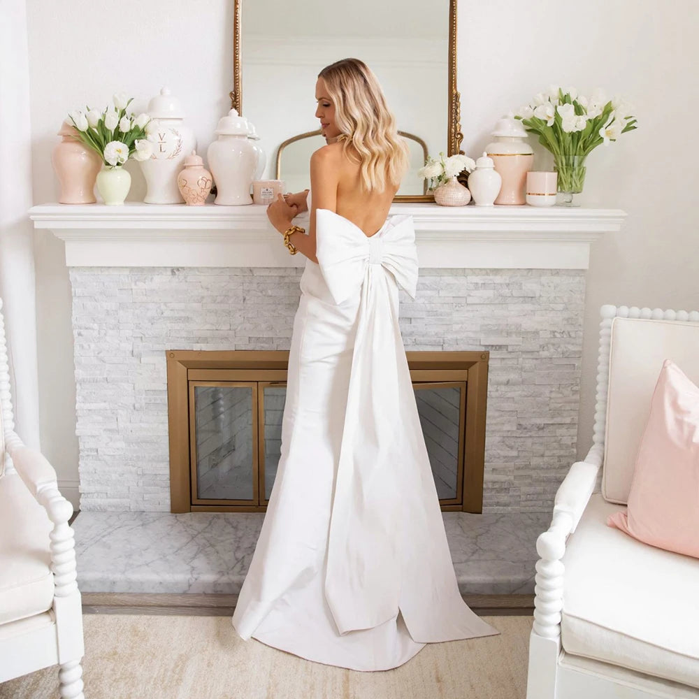Elevate your bridal look with the Robe Cupid. This elegant satin gown features a detachable bow train for versatility and a simple design that exudes sophistication. The perfect choice for a classic and timeless bridal ensemble, made for the modern bride.