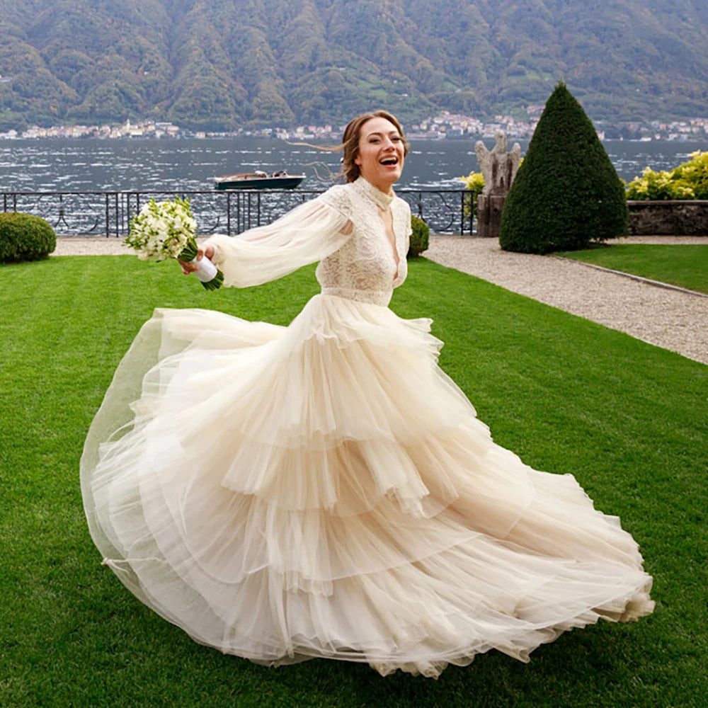 Indulge in sophistication and elegance with our Robe Tali. Featuring long Bishop sleeves, a high neck, and a vintage rustic design, this ball gown is the epitome of luxury. Delicate lace detailing, an open back, and a deep V keyhole add to the allure, making you the center of attention on your special day.