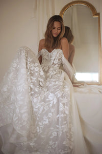 Introducing the Robe Romany, a stunning wedding dress that exudes elegance and sophistication. With its off-shoulder design and A-line silhouette, this dress is perfect for any bride looking to make a statement on their special day. Its luxurious look and feel will make you feel like a true queen on your wedding day.