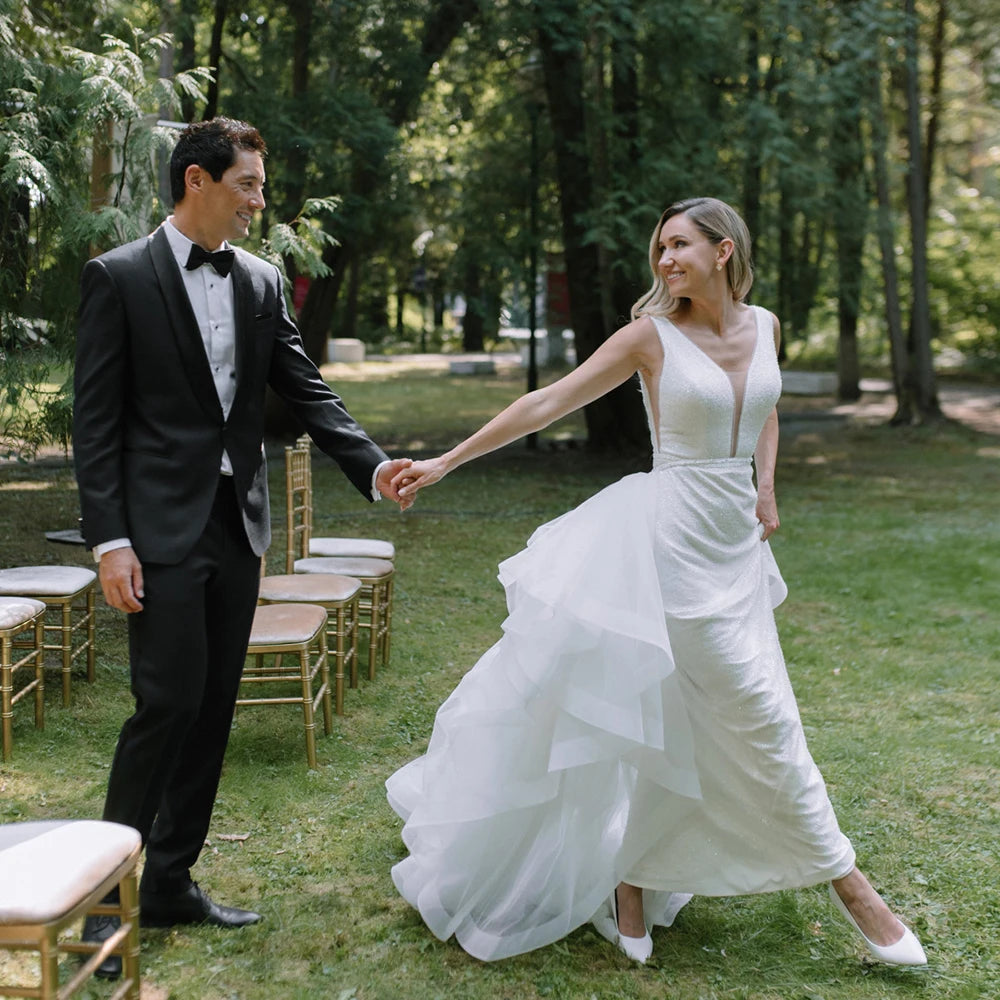 The Robe Elida offers a timeless and elegant design with its beaded mermaid silhouette and minimalist v-neckline. Handcrafted with luxury materials, this custom-made wedding dress also features a detachable tulle train for added dramatic effect. Perfect for the modern bride looking for a touch of glamour on her special day.