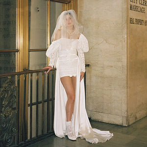 Indulge in elegance with Dress Mia: a stunning wedding dress with a sweet square neck, long fluffy sleeves, and custom-made ruching. The A-line silhouette and shirred straps create a flattering shape, while the luxurious satin fabric adds a touch of sophistication. Make your special day even more memorable with this exclusive dress.