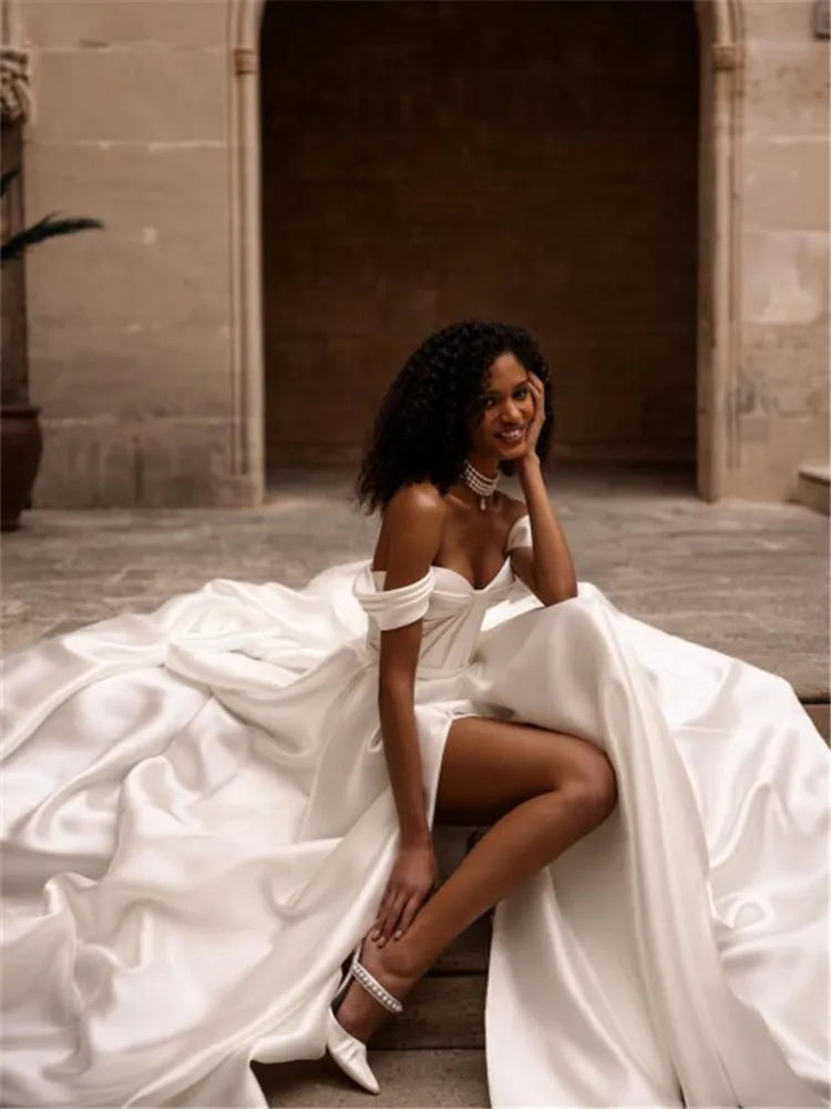 Indulge in luxury with our Robe Ivette. Made from smooth satin, this off-shoulder wedding dress exudes elegance and charm. Its simple design and lightweight material make it perfect for a beach wedding. Complete your bridal look with our exclusive Robe Ivette and feel like a true bride on your special day.