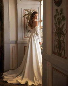 Elevate your special day with the Robe Clemance. This mermaid satin wedding dress features a draped train, high side slit, and long sleeves for a touch of elegance. Feel confident and beautiful as you walk down the aisle.