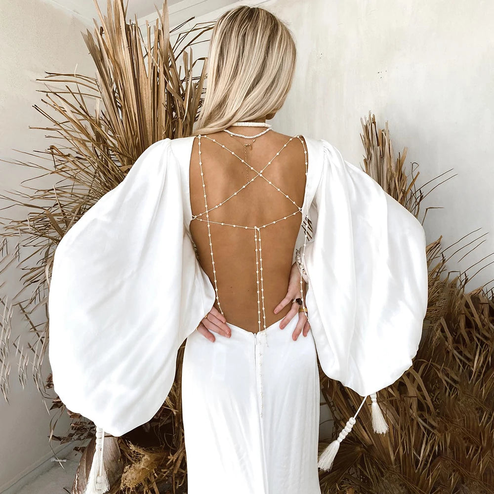 Indulge in the luxurious elegance of the Robe Suzanne. Featuring long bishop sleeves, an open back, and a side cutout, this custom-made wedding gown is made of flowing chiffon, accentuating every curve. With a sexy V-neck design, this dress is perfect for the modern bride looking for a simple yet stunning look.