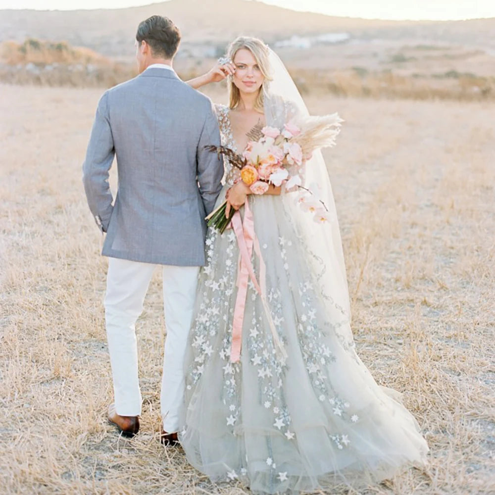 Experience the magic of a star studded night in our stunning Pauline Robe! This three-quarter sleeved gown boasts an A-line silhouette, V-neckline, and backless design. Sheer tulle with sparkling accents creates a beautiful and romantic look perfect for your wedding day. Capture stunning memories in this unique and gorgeous bridal gown!