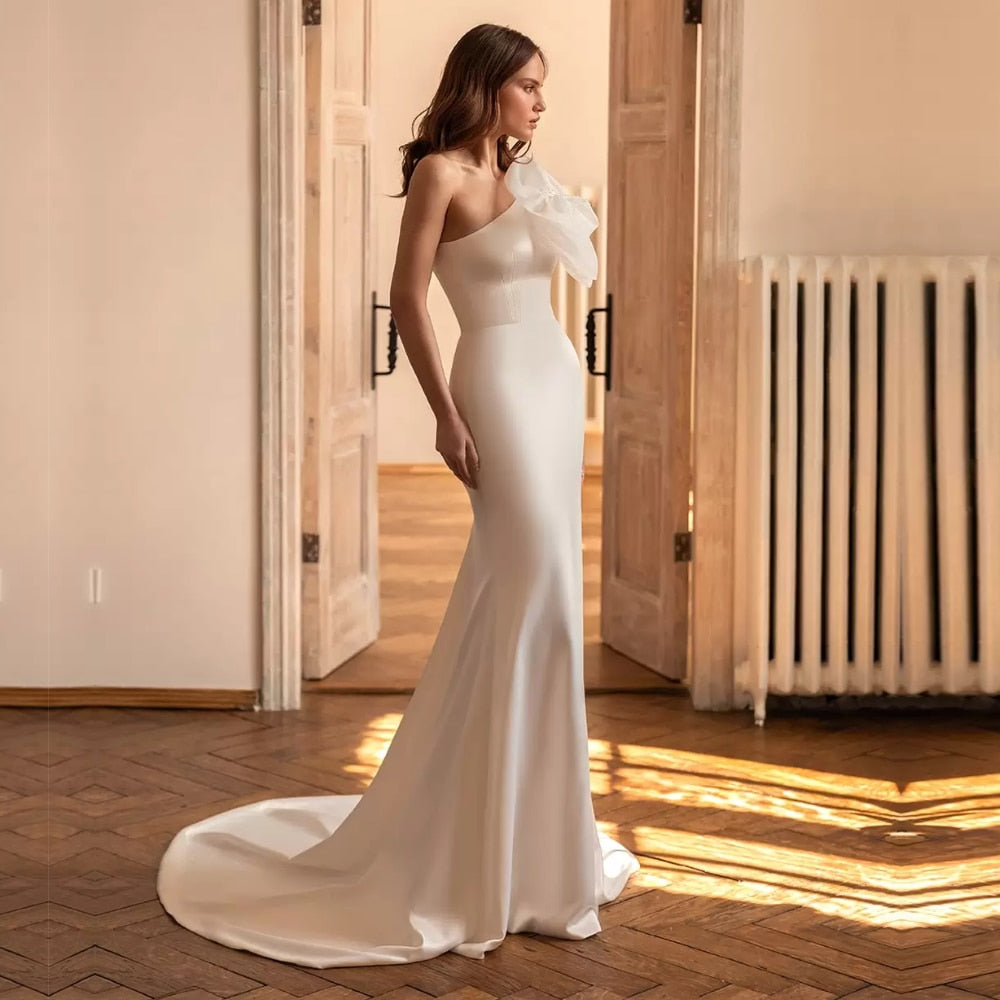 Make a statement with the Robe Charlotte – the perfect one shoulder, sophisticated bridal look. Dare to stand out and make your wedding day unforgettable! Show off your bold style as you walk down the aisle in this daring yet timeless piece.
