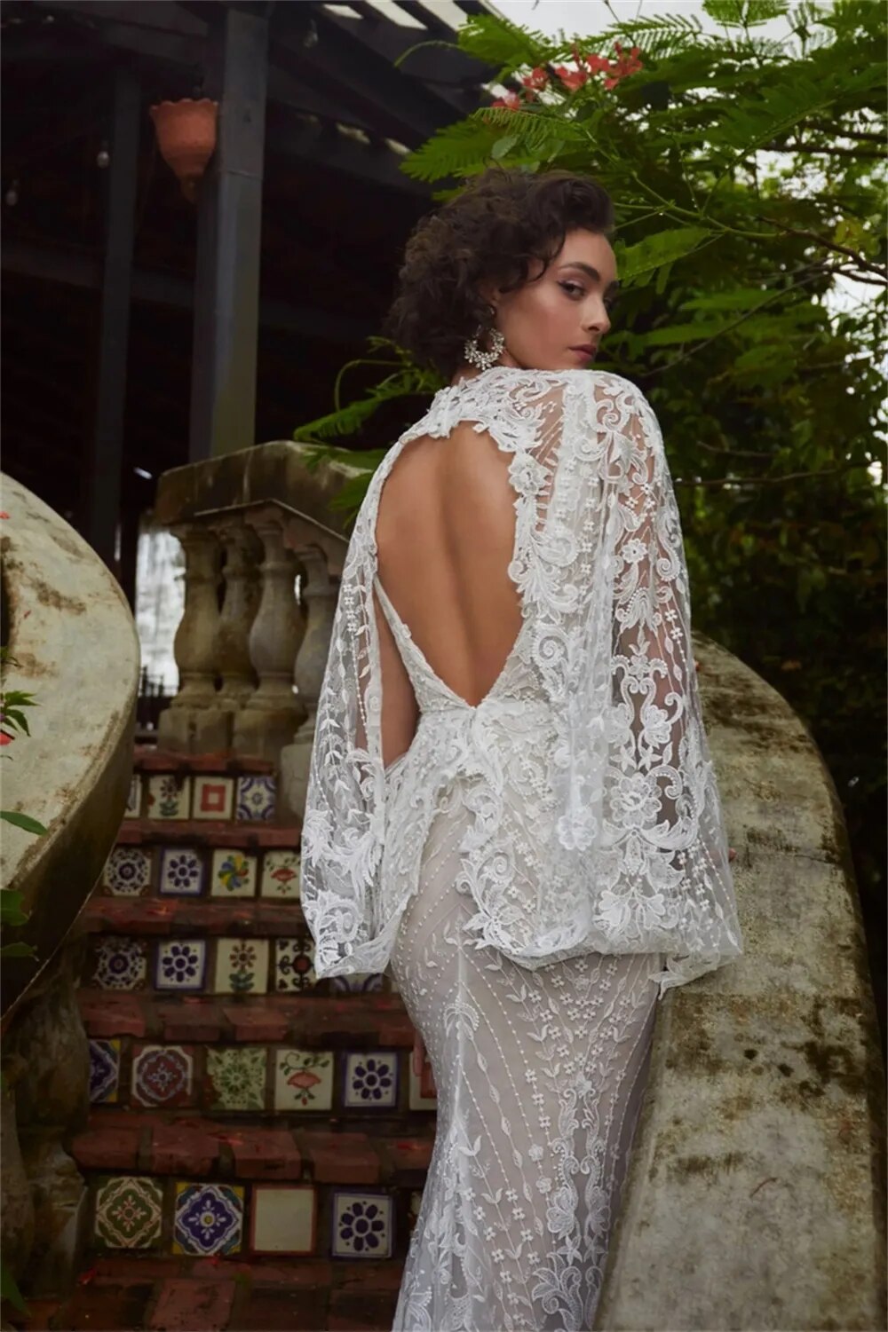 Elevate your special day in the Robe Jacqueline. This exquisite mermaid-style dress is crafted with V-neck and brush floor-length silhouette. Featuring an open back and handmade flower lace accents, this wedding dress is sure to make an unforgettable impression.