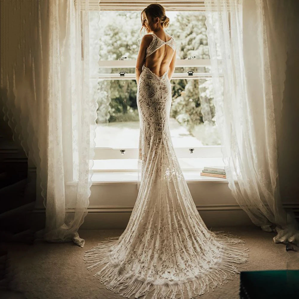 Unleash your inner bride in our Robe Tali - the perfect combination of elegance and rustic charm. Featuring a fringed sheath lace design, this custom-made wedding dress is sure to turn heads. The deep v-neck and halter style add a touch of romance, while the fitted silhouette flatters all sizes. Say "I do" in style with our Robe Tali.