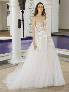 Get ready to stun in our Dress Bella! This A-line bridal gown features a plunging sweetheart neckline, exposed corset, and illusion cut-outs for a daring yet elegant look. The high split adds a touch of drama, making you the show-stopper on your special day.