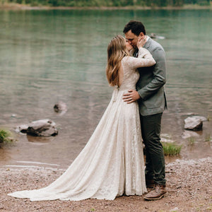 Capture effortless elegance in the Francine robe! With soft lace, dramatic sleeves, a peek-a-boo back, and romantic tassels, this captivating custom-made gown is perfect for a beach elopement. Create memories that will last a lifetime in this daring design!