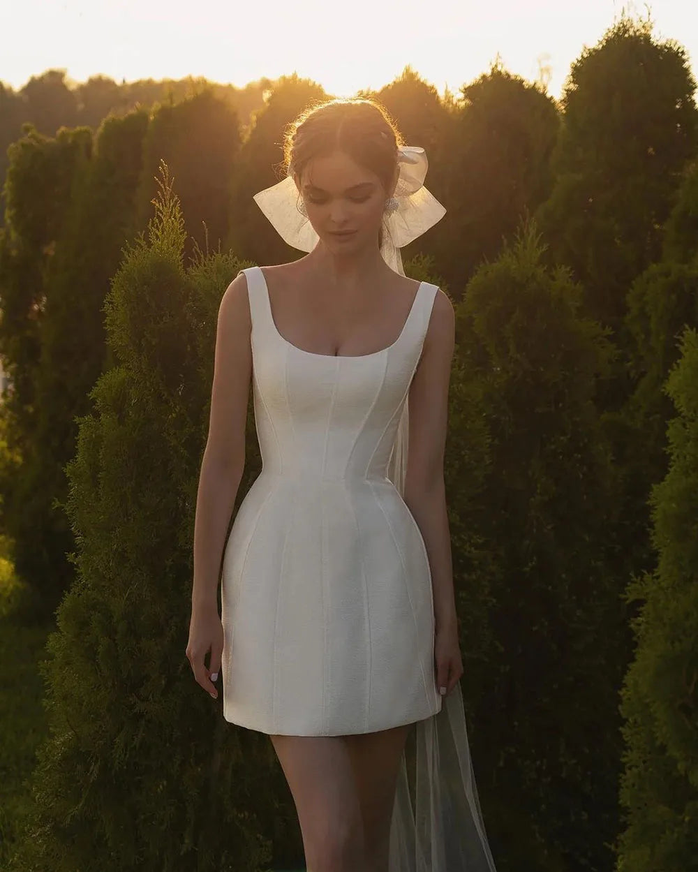 The Robe Chloé features a square neck and a boning fitted bodice that creates an elegant and chic look, perfect for any party or special occasion. Its mini short design adds a modern touch, making it a versatile and stylish choice for weddings. Say "I do" in style with this elegant and flattering dress.